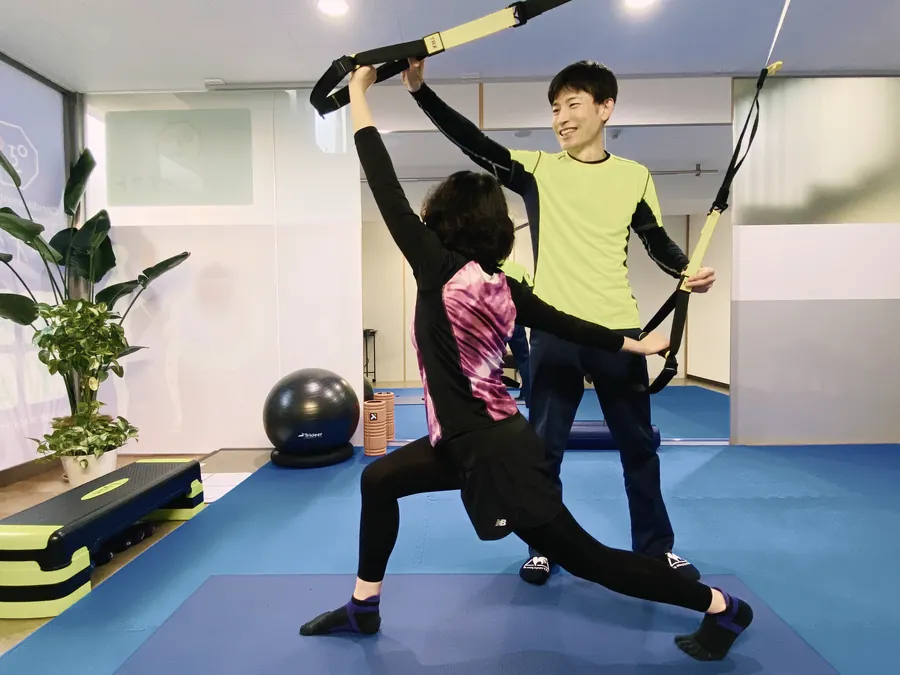 コンディショニングルームで、つり下げ式の器具(TRX)を使った運動